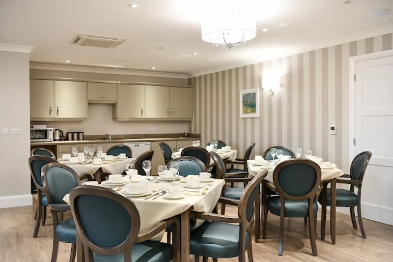 dining room with blue chairs and tables setup with crockery